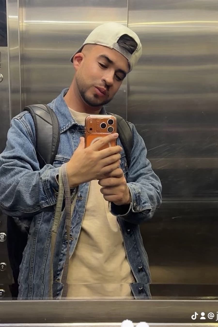 OOTD del día 🧢✨
Un look casual urbano con inspiración streetwear, cómodo pero bien estructurado:
* 🧢 Gorra beige/crema llevada hacia atrás.
* 👕 Camiseta básica color crema, de corte relajado.
* 🧥 Chaqueta de mezclilla azul claro, ligeramente oversize, que aporta textura y contraste.
* 🎒 Mochila negra de estilo urbano, con correas anchas.
* 📱 Accesorio protagonista: smartphone con funda en tono café/caramelo.
* 👖 La parte inferior no es visible en la fotografía, por lo que no la describiría para evitar inventar detalles. @brijeey